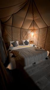 Ένα ή περισσότερα κρεβάτια σε δωμάτιο στο Merzouga Chic Luxury Camps
