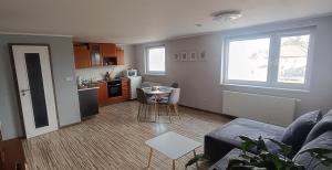 a living room with a couch and a kitchen at Apartmán s výhľadom na Bojnický zámok in Bojnice