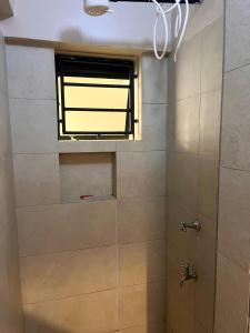 Un baño con ducha con ventana. en Romish Luxury Homes, en Nairobi