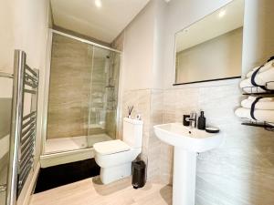 a bathroom with a toilet and a sink and a shower at Prime Leeds- Spacious Cinema apartment in Central Station