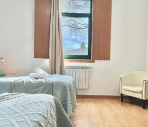 een slaapkamer met twee bedden en een raam bij Complexo Xacobeo in Tríacastela
