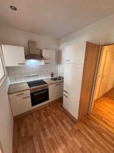 a kitchen with white appliances and a wooden floor at Apartments Haar in Haar