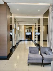 a lobby with two chairs in a building at 1-BR Luxury Condo, Centrio Tower, Ayala Malls in Cagayan de Oro