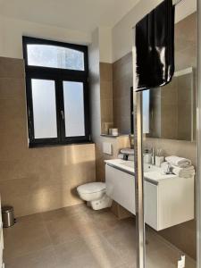 a bathroom with a toilet and a sink and a mirror at Loft Luna Brussels Midi in Brussels +8 photos