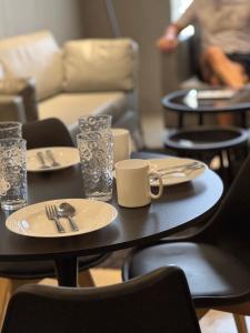 two tables with plates and utensils on them at 1-BR Luxury Condo, Centrio Tower, Ayala Malls in Cagayan de Oro
