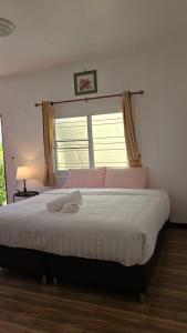 ein Schlafzimmer mit einem großen Bett mit Fenster in der Unterkunft Smile house 354 in Chiang Rai