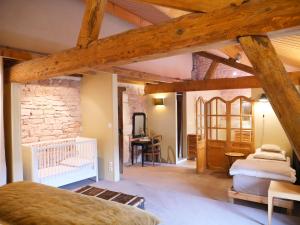 a room with two beds and a stone wall at Le Clos de Miribel in Givry