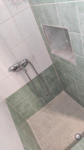 a shower in a bathroom with green and white tile at Family House , Amazing Sea View in Kamarai