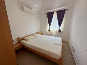 a bedroom with a bed and a window at Apartments Villa Eva in Slano