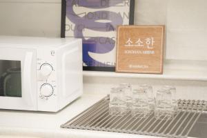 a row of glasses on a shelf next to a microwave at SOSOHAN Gyesan Station 1 minute Super Station Area House 1st Floor Accommodation for 8 people 3 rooms Incheon Airport 40 minutes,Gimpo Airport 30 minutes in Incheon