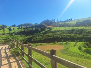 a wooden fence on a dirt road in a field at Recanto Tangará in Socorro