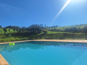 a swimming pool with a view of a vineyard at Recanto Tangará in Socorro