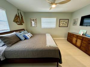 a bedroom with a bed and a ceiling fan at Blue Heron House, Private 4 BR Waterfront w Heated Pool and Fire Pit in Ruskin