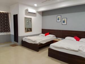 a room with two beds in a room at Infinity Rooms D-Mart in Surat