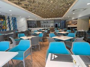 a dining room with blue chairs and tables at The beach front Condo in Ban Saiyuan (1)