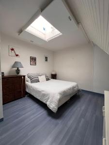 a bedroom with a large bed and a skylight at Duplex en plein centre, 3min plage in Deauville