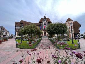 a large house with a garden in front of it at Duplex en plein centre, 3min plage in Deauville