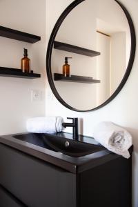 a bathroom with a black sink and a mirror at Villa avec piscine, Sainte Marguerite in Pornichet