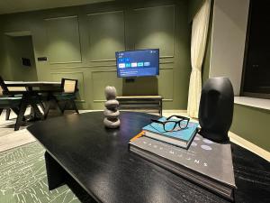 a living room with a table with a book and a tv at Plush Bandra West - Luxury 2BHK Apartment & Study in Mumbai