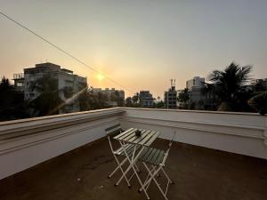a chair sitting on a balcony with a view of a city at Plush Bandra West - Luxury 2BHK Apartment & Study in Mumbai