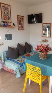 a room with a bed with a table and flowers at La Dolce Vita - Apartment with shared pool and large terrace in Lido delle Nazioni