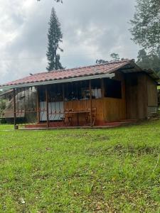 ein kleines Haus mit einem Grasfeld davor in der Unterkunft Cabañita en el Parque Natural Ecocenter in Santandercito