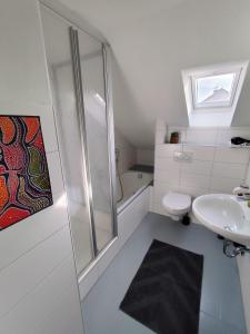 Un baño con ducha, lavabo e inodoro. en Ferienwohnung Down Under am Bodensee, en Uhldingen-Mühlhofen 12 fotos más