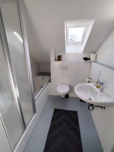 Un baño con inodoro, lavabo y ducha. en Ferienwohnung Down Under am Bodensee, en Uhldingen-Mühlhofen
