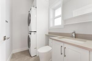 a white bathroom with a refrigerator and a sink at Charming 3BR Home in a Lovely Vancouver Neighborhood in Vancouver