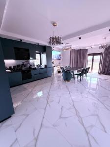 a large white room with a dining room and a kitchen at VILA Neptun Jacuzi SPA in Săcele