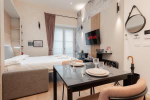 a room with a bed and a table and chairs at Casa Giusy Esclusiva Suite Molinette Torino in Turin