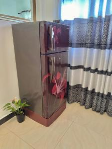 a refrigerator with a flower painted on it next to a window at Angel White in Unawatuna in Unawatuna