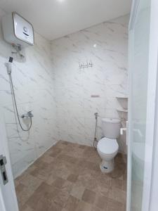 ヌサドゥアにあるKos Elite Yoellのトイレとシャワー付きの白いバスルーム