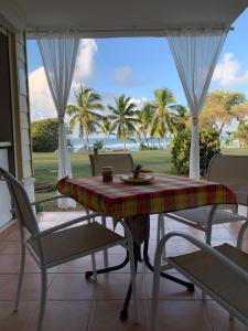 a table and chairs in a room with a view of the ocean at Sainte-Anne in Sainte-Anne