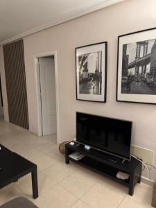 a living room with a flat screen tv on a wall at Fresh apartment, 2 bedroom, 2 bathroom, 2 lovely poolareas in Los Alcázares