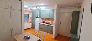 a kitchen with blue cabinets and a table in it at La Bloc Apartment in Arad