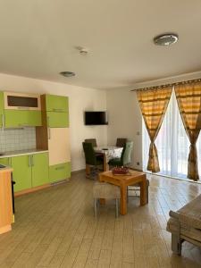 a living room with green cabinets and a table at Apartments Villa Eva in Slano