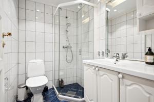 a bathroom with a shower and a toilet and a sink at Apt 500 m to Bryggen - Perfect location in Bergen +3 photos