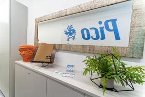 an office with a sign on a counter with plants at Pico Apartments - Roma 20 in Sanremo