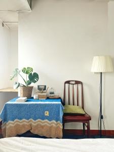 a table with a chair and a plant and a lamp at Nằm Mơ 1 Homestay - chi Nhánh Ngô Thì Sỹ in Da Lat