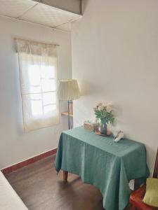 a table with a green table cloth and a window at Nằm Mơ 1 Homestay - chi Nhánh Ngô Thì Sỹ in Da Lat