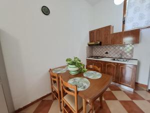 a small kitchen with a wooden table and chairs at Hotel Sirena in Vlorë