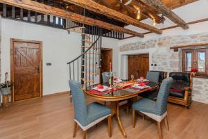 a dining room with a wooden table and chairs at Kuća za odmor Niko in Škabrnje