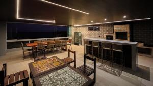 a dining room with a table and a bar at Casa do Mineiro Jacumã RN in Ceará-Mirim