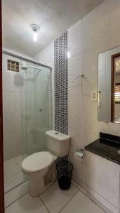 a bathroom with a toilet and a glass shower at Casa do Mineiro Jacumã RN in Ceará-Mirim +59 photos