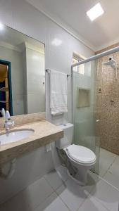 a bathroom with a toilet and a sink and a shower at Casa do Mineiro Jacumã RN in Ceará-Mirim