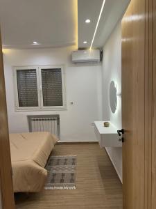 a bedroom with a bed and a sink and a mirror at DARZAYNAH in Monastir +12 photos