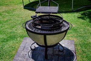 a grill sitting on top of the grass at Dulce Vita Self-Catering Duet in Bloemfontein