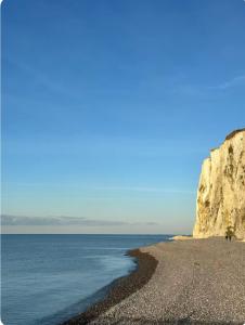 a beach with a cliff and the ocean at Le Bel Air -jardin - proche Mer & parking gratuit in Mers-les-Bains