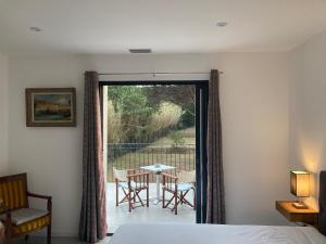 a bedroom with a bed and a balcony with a table and chairs at Loumar in Saint-Tropez